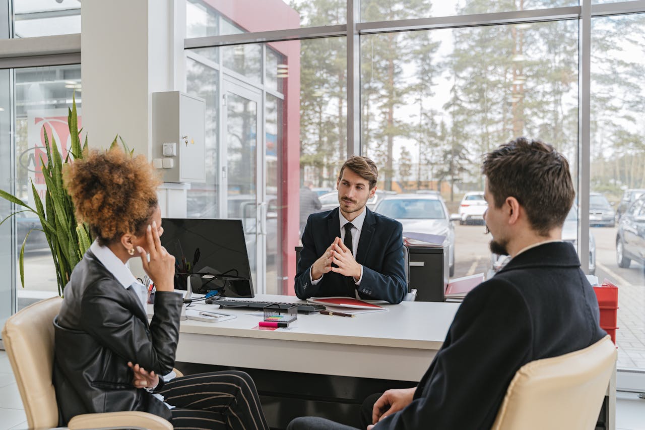 Three adults in a modern office setting having a professional business meeting.